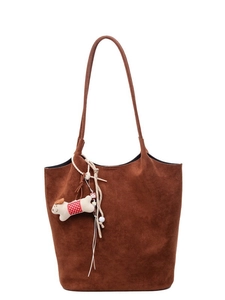 Brown suede tote bag with dog plush charm and long shoulder strap on white background