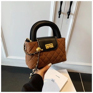 Close-up of brown quilted bag with gold twist lock and metallic ball chain detail