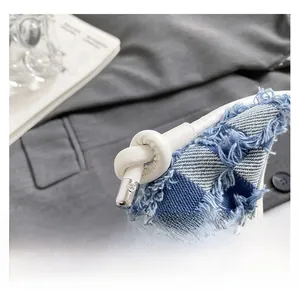 Macro detail of checkered denim fabric with frayed edges and knotted leather strap