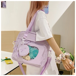 Detailed view of lavender purple ita bag with heart-shaped window and plush charms