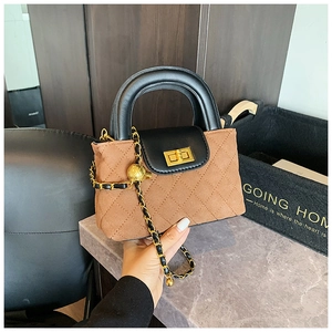 Detail of quilted brown suede crossbody bag with gold twist lock and metal chain strap