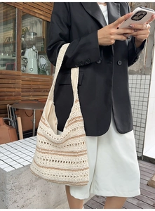 Detail of striped woven shoulder bag with wide strap and soft cotton crochet texture