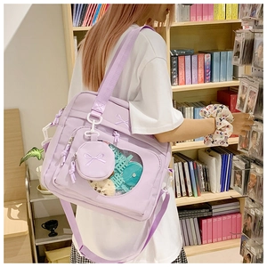 Detailed view of lavender canvas Ita bag with clear display window and plush decorations