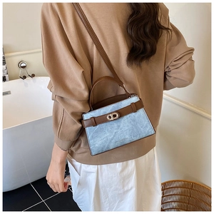 Close-up of small crossbody bucket bag with blue marble texture and leather trim