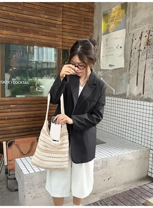 Detail of beige hollow-out crochet shoulder bag with striped texture in street style