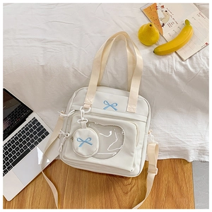 White canvas tote bag with heart-shaped window and blue bow embroidery detail