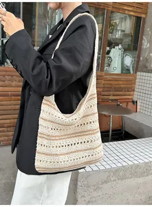 Detail of bohemian hollow crochet woven tote bag with beige stripes for women