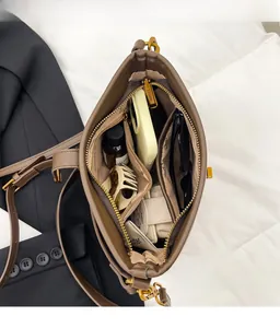 Internal view of brown leather bucket bag showing large capacity and zipper compartments