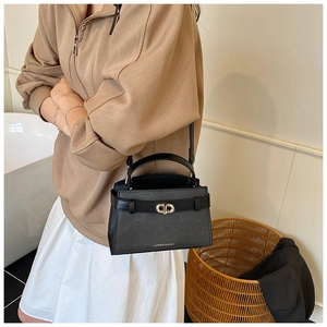 Detail of a chic black bucket bag with silver interlocking clasp and brand logo