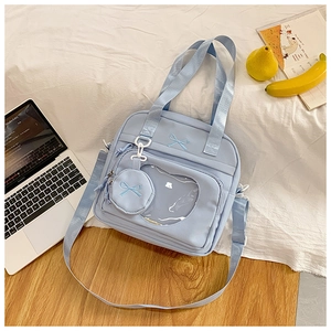 Detail of light blue ita bag showing cat-shaped clear window and bow embroidery