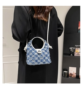 Detail of plaid denim bucket bag with frayed edges shown on model for size perspective