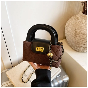Close-up of brown quilted handbag with black leather flap and golden adjustable ball chain