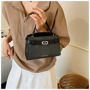 Close-up of black matte leather bucket bag with silver buckle and brand logo detail