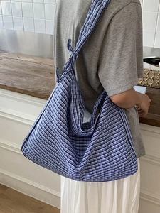 Blue and white plaid hobo bag with tie strap detail for casual commute style