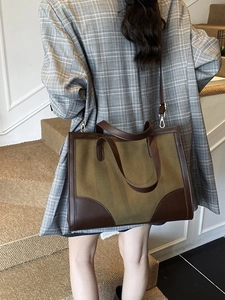 Grand sac cabas rétro bicolore en cuir marron et daim olive porté par un mannequin