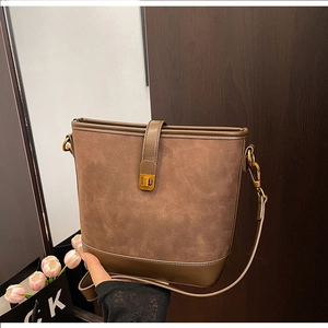 Detail view of vintage dark brown bucket bag with gold metal twist lock and matte finish