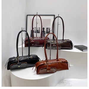 Artistic display of glossy leather shoulder bags in four vintage colors on white pedestals