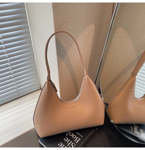 Detailed close-up of litchi texture leather hobo bag with gold logo and zipper