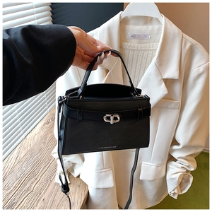 Detail of black leather bucket bag featuring silver twist lock and adjustable shoulder strap