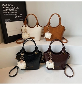 Four vintage bucket bags in neutral tones featuring glossy pleated leather and sheep charms