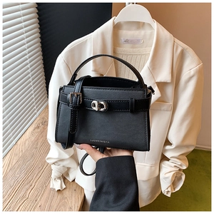 Close-up of black crossbody bucket bag featuring silver hardware and textured leather