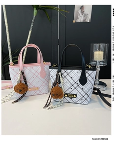 Detail of plaid bucket bags with bear charms and metal logo on a minimalist background