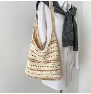 Detail of hand-woven hobo bag with brown stripes styled on a fashion mannequin