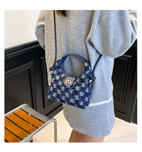 Close-up of blue and white checkered denim bucket bag featuring frayed edges and silver clasp