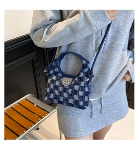 Detailed view of blue and white plaid tweed bucket bag with silver twist-lock closure