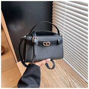 Close-up of black crossgrain leather bucket bag with gold buckle and adjustable strap