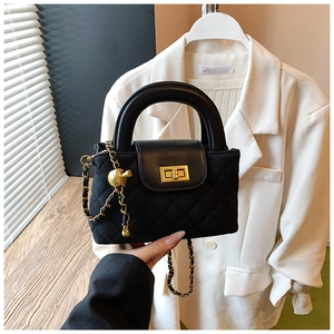 Detailed shot of a black quilted handbag with a gold twist lock and sphere chain strap