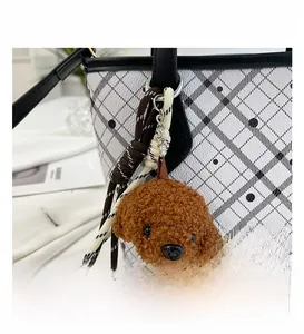 Close-up of white checkered bucket bag with black polka dots and cute dog plush pendant