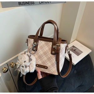 Close-up of color-block checkered handbag with premium leather trim and bunny charm