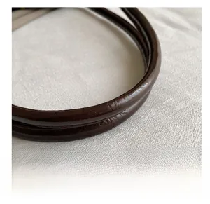 Macro detail of high-quality dark brown leather handle on vintage shoulder baguette bag