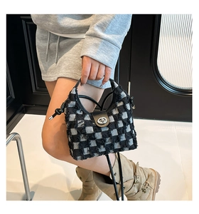 Detail of checkered denim bucket bag with frayed edges and silver metal twist lock