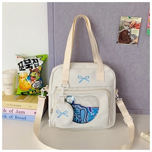 Detail of cream tote bag with blue bow embroidery and heart-shaped clear window display