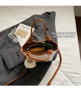 Detail of a white bucket bag interior showing spacious capacity on a grey suit jacket