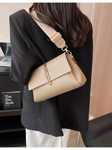 Chic beige and coffee crossbody bag with wide strap worn over a black blazer