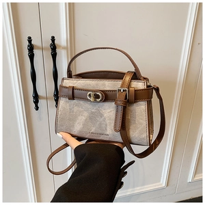 Detail of vintage denim canvas and brown leather crossbody bucket bag with metal lock