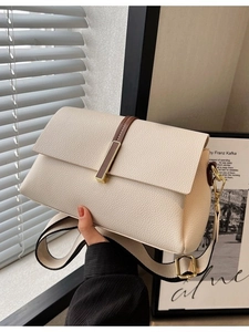 Chic beige textured leather crossbody bag with wide patterned strap and gold hardware