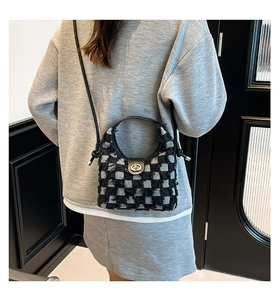 Detailed back view of a plaid denim bucket bag with fringe and metal twist lock closure