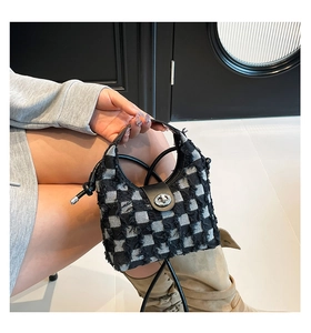 Chic black and white checkered tweed bucket bag with leather strap and metal swivel lock