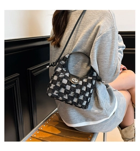 Detail of checkered plush bucket bag with metal twist lock and slim shoulder strap