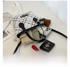 Detail showing the large interior capacity of this plaid bucket bag with daily essentials