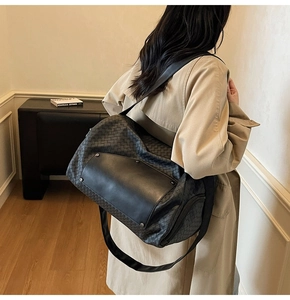 Vista dettagliata della borsa da viaggio in pelle intrecciata nera con tracolla regolabile