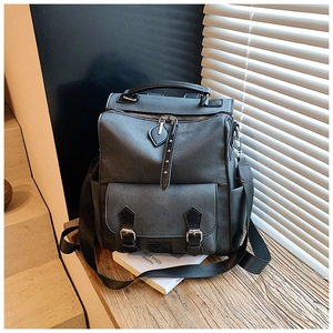 Detail of dark gray matte leather backpack with silver hardware and adjustable straps