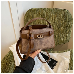 Close-up of brown crossbody bucket bag with marble texture and gold buckle detail