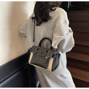 Detail of contrast stitching and mixed leather-canvas texture on a stylish bucket bag