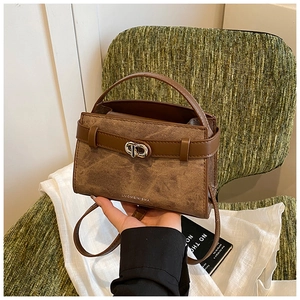 Close-up of vintage brown leather bucket bag with retro metal twist lock and handle