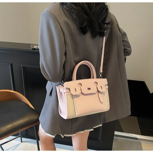 Detail of light pink leather and canvas contrast handbag with adjustable shoulder strap
